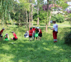 Dvě holčičky v&nbsp;kostýmu lesních víl v&nbsp;trávě v&nbsp;parku, o&nbsp;které se stará soutěžní tým 5 žáků, u&nbsp;nich jsou dva přihlížející rozhodčí.